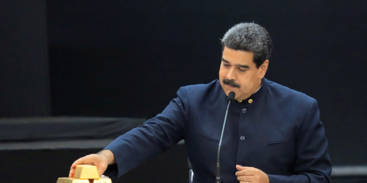 Foto de archivo del presidente de Venezuela, Nicolás Maduro, tocando una barra de oro durante una reunión con ministros del área económica en Caracas. 22 de marzo de 2018. REUTERS/Marco Bello.