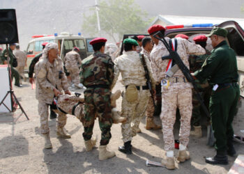 Soldiers carry the injured following a missile attack on a military parade during a graduation ceremony for newly recruited troopers in Aden, Yemen August 1, 2019. REUTERS/Fawaz Salman