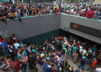 CAR03. CARACAS (VENEZUELA), 29/08/2018.- Personas aguardan en la entrada de una estación del Metro de Caracas después de una interrupción del servicio tras un corte de energía hoy, miércoles 29 de Agosto, en Caracas (Venezuela). El transporte público colapsó hoy en Caracas tras un breve corte de energía eléctrica que afectó el servicio del Metro y obligó a los usuarios a caminar varios kilómetros para llegar a sus destinos, pudo constatar Efe. EFE/Cristian Hernández