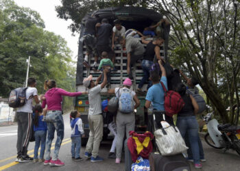 Venezuelan migrants climb on a truck on the road from Cucuta to Pamplona, in Norte de Santander Department, Colombia, on February 10, 2019. - Opposition leader Juan Guaido, recognized by some 50 countries as Venezuela's interim president, warned the military Sunday that blocking humanitarian aid from entering the country is a "crime against humanity." (Photo by Raul ARBOLEDA / AFP)