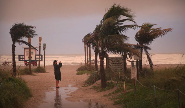 COCOA BEACH, FLORIDA - SEPTEMBER 02: A woman takes a picture as the effects of Hurricane Dorian begin to be felt on September 2, 2019 in Cocoa Beach, Florida. Dorian, once expected to make landfall near Cocoa Beach as a category 4 storm, is currently predicted to turn north and stay off the Florida coast, lessening the impact on the area.   Scott Olson/Getty Images/AFP