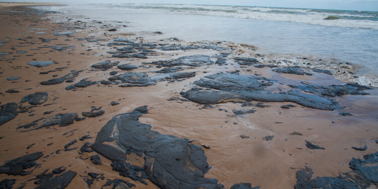 Handout picture released by the Sergipe State Environment Administration (Ademas) on September 25, 2019, showing oil spilled on a beach in Pirambu, Sergipe state, Brazil. - Brazil's President Jair Bolsonaro said on October 7 that the mysterious oil stains that appeared on 132 beaches in northeastern Brazil haver their origin in another country, wihtout mention which one. (Photo by HO / ADEMAS / AFP) / RESTRICTED TO EDITORIAL USE - MANDATORY CREDIT "AFP PHOTO / ADEMAS / Marcos Rodrigues" - NO MARKETING - NO ADVERTISING CAMPAIGNS - DISTRIBUTED AS A SERVICE TO CLIENTS