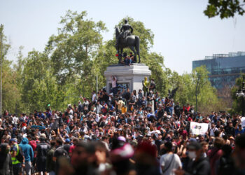 People prostest at Plaza Italia square in Santiago, Chile, on October 21, 2019. - Chile's death toll has risen to 11, authorities said on Monday, after three days of violent demonstrations and looting that saw President Sebastian Pinera claim the country was "at war." (Photo by Pablo VERA / AFP)