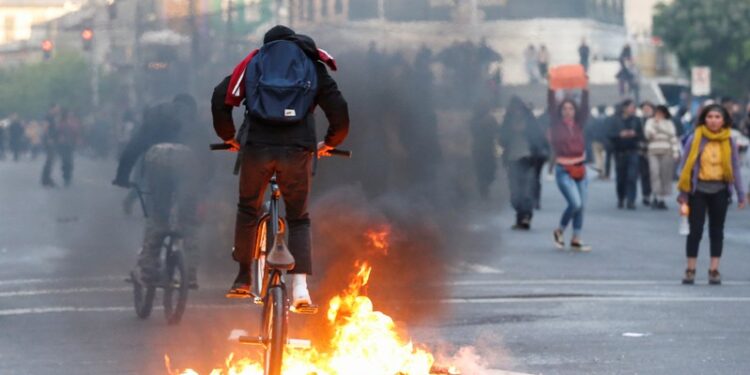 A demonstrator cycles over burning objects on a road during a protest against the government in Valparaiso, Chile October 19, 2019. REUTERS/Rodrigo Garrido
Referencial