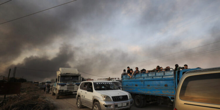 People stand at a back of a truck as they flee Ras al Ain town, Syria October 9, 2019. REUTERS/Rodi Said