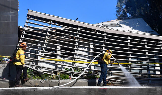 Firefighters work outside a destroyed home along North Tigertail Road near The Getty Center in Los Angeles, California on October 29, 2019. - More than 1,000 firefighters battled a wind-driven blaze Monday that broke out near the renowned Getty Center in Los Angeles, prompting widespread evacuations as the flames destroyed several homes and forced the shutdown of schools and roads. The so-called Getty Fire ignited overnight near a major freeway and quickly spread south and west towards neighborhoods, scorching some 600 acres (240 hectares) and sending people fleeing in the dark. (Photo by Frederic J. BROWN / AFP)