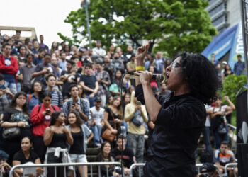 A member of a band performs during the New Bands Festival at the Altamira square in Caracas, on October 20, 2019. - The New Bands Festival is one of the few spaces which promote Venezuelan alternative musicians, for whom making music is a fight against precariousness and censorship. (Photo by Yuri CORTEZ / AFP)