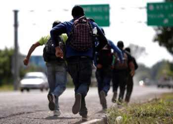 Men belonging to a caravan of migrants from El Salvador en route to the United States, run after they perceive the presence of police at the entrance of Tecun Uman, Guatemala, November 1, 2018. REUTERS/Ueslei Marcelino