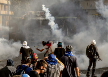 Demonstrators clash with riot police during a protest against the government of President Sebastian Pinera, in Santiago, on January 24, 2020. - Demonstrations which began on October 18, 2019, initially against a modest metro fare hike, quickly escalated and left 29 people dead amid accusations of a heavy-handed response from security forces. (Photo by Martin BERNETTI / AFP)