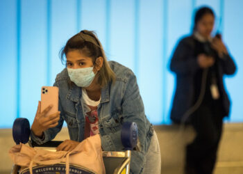 Passengers wear protective masks to protect against the spread of the Coronavirus as they arrive at the Los Angeles International Airport, California, on January 22, 2020. - A new virus that has killed nine people, infected hundreds and has already reached the US could mutate and spread, China warned on January 22, as authorities urged people to steer clear of Wuhan, the city at the heart of the outbreak. (Photo by Mark RALSTON / AFP)