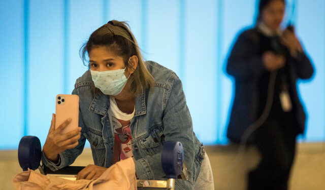 Passengers wear protective masks to protect against the spread of the Coronavirus as they arrive at the Los Angeles International Airport, California, on January 22, 2020. - A new virus that has killed nine people, infected hundreds and has already reached the US could mutate and spread, China warned on January 22, as authorities urged people to steer clear of Wuhan, the city at the heart of the outbreak. (Photo by Mark RALSTON / AFP)