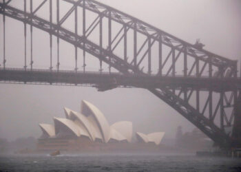 FILE PHOTO: A boat passes under the Sydney Harbour Bridge and in front of the Sydney Opera House as strong winds and heavy rain hit the city of Sydney, Australia, November 28, 2018.    REUTERS/David Gray