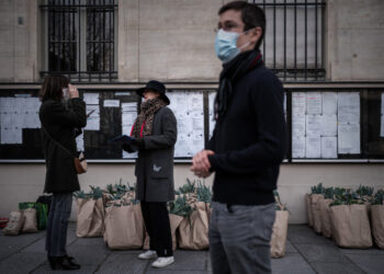 A member of an AMAP (association for the preservation of local farming) waits for others to come and pick up their weekly basket of fresh locally farmed vegetables in Paris on March 18, 2020 as a strict lockdown came into in effect in France to stop the spread of the COVID-19 disease caused by the novel coronavirus. (Photo by Philippe LOPEZ / AFP)