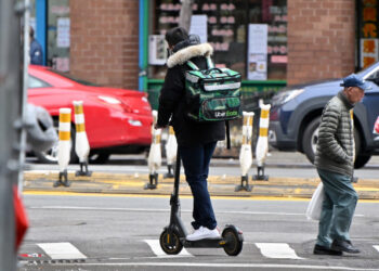 NEW YORK, NEW YORK - MARCH 19: An Uber Eats delivery worker is seen riding an electric scooter in Manhattan's Chinatown on March 19, 2020 in New York City. Schools, businesses and most places where people congregate across the country have been shut down as health officials try to slow the spread of COVID-19.   Dia Dipasupil/Getty Images/AFP