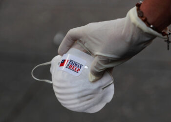 A member of the Taiwan and Venezuela Parliamentary Friendship team distributes face masks to people outside a metro station, in response to the spreading coronavirus (COVID-19), in Caracas, Venezuela March 12, 2020. REUTERS/Carlos Jasso