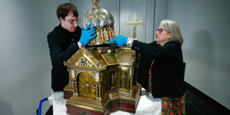 El restaurador Luke Jonathan Koeppe y la directora de la Cámara del Tesoro de la Catedral de Aquisgrán, Birgitta Falk, presentan el relicario con las reliquias de Santa Corona, patrona de las epidemias, en la Catedral de Aquisgrán, Alemania. 25 de marzo, 2020.  REUTERS/Thilo Schmuelgen