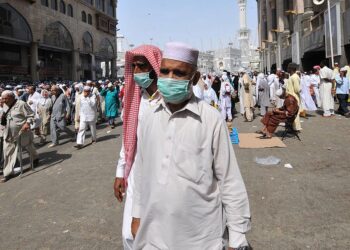 Muslim pilgrims wearing a mask leave after the Friday prayer at Mecca's Grand Mosque, on October 11, 2013 as hundreds of thousands of Muslims have poured into the holy city of Mecca for the annual hajj pilgrimage. The hajj is one of the five pillars of Islam and is mandatory once in a lifetime for all Muslims provided they are physically fit and financially capable.  AFP PHOTO/FAYEZ NURELDINE        (Photo credit should read FAYEZ NURELDINE/AFP via Getty Images)