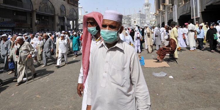 Muslim pilgrims wearing a mask leave after the Friday prayer at Mecca's Grand Mosque, on October 11, 2013 as hundreds of thousands of Muslims have poured into the holy city of Mecca for the annual hajj pilgrimage. The hajj is one of the five pillars of Islam and is mandatory once in a lifetime for all Muslims provided they are physically fit and financially capable.  AFP PHOTO/FAYEZ NURELDINE        (Photo credit should read FAYEZ NURELDINE/AFP via Getty Images)