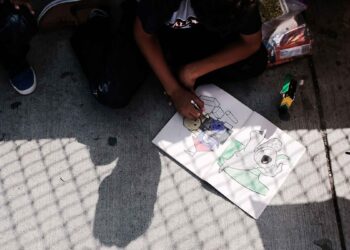 BROWNSVILLE, TX - JUNE 25:  A Honduran child works in a coloring book while waiting with his family along the border bridge after being denied entry from Mexico into the U.S. on June 25, 2018 in Brownsville, Texas. Immigration has once again been put in the spotlight as Democrats and Republicans spar over the detention of children and families seeking asylum at the border. Before President Donald Trump signed an executive order last week that halts the practice of separating families who are seeking asylum, more than 2,300 immigrant children had been separated from their parents in the zero-tolerance policy for border crossers.  (Photo by Spencer Platt/Getty Images)