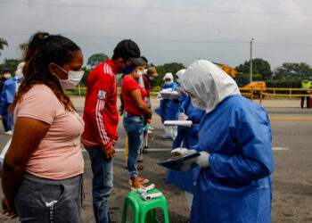 Staffers from the Secretary of Health check Venezuelans while returning to the country from Colombia, as a preventive measure against the spread of the coronavirus -COVID19- at the Simon Boliviar International Bridge, in Cucuta, Colombia-Venezuela border, on April 4, 2020. - Since the first case of COVID-19 was detected last March 6, Colombia has reported 1,406 people infected and 32 dead. (Photo by Schneyder MENDOZA / AFP)