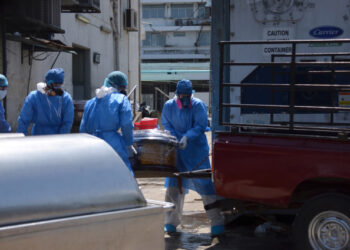 Health workers wearing protective gear load a coffin onto the back of a pick-up truck outside of Teodoro Maldonado Carbo Hospital amid the spread of the coronavirus disease (COVID-19), in Guayaquil, Ecuador April 3, 2020. Picture taken April 3, 2020. REUTERS/Vicente Gaibor del Pino NO RESALES. NO ARCHIVES