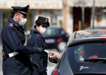 Carabinieri wearing protective face masks verify if a driver has a valid reason to travel during the lockdown to prevent the spread of coronavirus disease (COVID-19), at Piazza Venezia in Rome, Italy, March 21, 2020. REUTERS/Yara Nardi