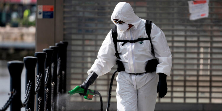 London (United Kingdom), 31/03/2020.- A cleaner sprays disinfectant outside the Emirates Air Line office in Central London, Britain, 31 March 2020. According to news reports, the NHS is anticipating a Coronavirus 'tsunami' as the peak of infection rates nears. British Prime Minister Boris Johnson has announced that Britons can only leave their homes for essential reasons or may be fined, in order to reduce the spread of the Coronavirus. (Reino Unido, Londres) EFE/EPA/WILL OLIVER