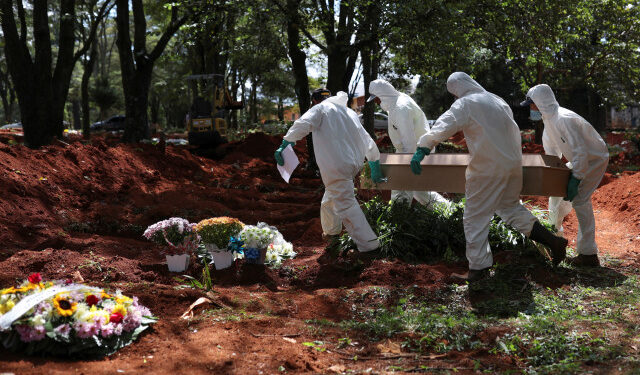 Gravediggers wearing protective suits carry the coffin of someone who died suspected to have had coronavirus disease (COVID-19), at Vila Formosa cemetery, Brazil's biggest cemetery, in Sao Paulo, Brazil, April 2, 2020. REUTERS/Amanda Perobelli