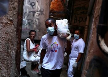 Un voluntario lleva comida a familias pobres de la Rocinha (REUTERS/Pilar Olivares/archivo)