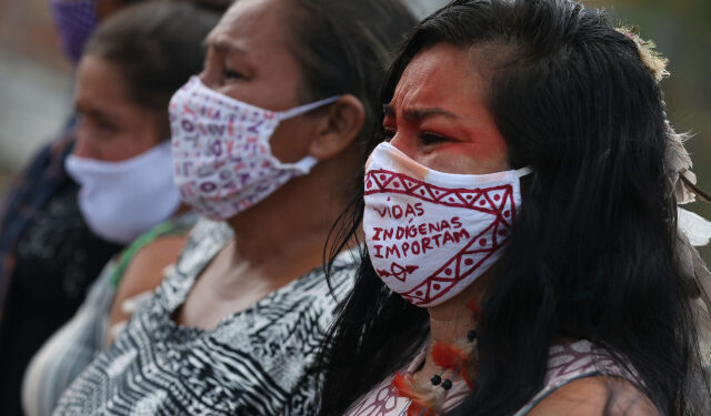 Indigenous women from the Parque das Tribos community mourn at the funeral of Chief Messias, 53, of the Kokama tribe who died victim of the new coronavirus, COVID-19, in Manaus, Brazil, on May 14, 2020. (Photo by MICHAEL DANTAS / AFP)