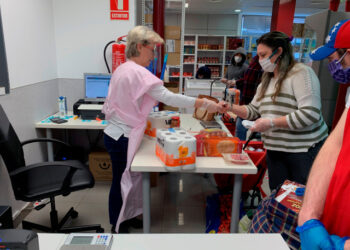 GRAF9022. MADRID, 21/05/2020.- Clientes y voluntarios de Cáritas, en el economato que esta organización tiene en el distrito madrileño de Tetuán, donde personas necesitadas pueden comprar alimentos y otros productos de primera necesidad a precio subvencionado. La crisis causada por la pandemia ha golpeado duro a las comunidades de latinoamericanos en España, con frecuencia en el nivel más frágil de la escala social, y ahora muchos de ellos se ven abocados a la pobreza y a la ayuda para sobrevivir. A menudo atrapados en empleos temporales o informales, los latinos se han visto afectados de forma desmedida por el huracán que se ha llevado por delante, hasta ahora, casi 950.000 empleos. EFE/Rafael Cañas