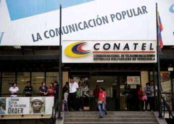 FILE PHOTO: A woman walks out from the building of the National Commission of Telecommunications (CONATEL), in Caracas, Venezuela February 16, 2017. REUTERS/Marco Bello/File Photo