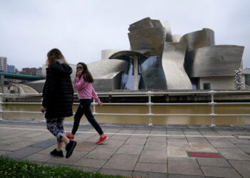 A family walks past the Guggenheim Museum, after restrictions were partially lifted for children for the first time in six weeks, during the coronavirus disease (COVID-19) outbreak in Bilbao, Spain, April 26, 2020. REUTERS/Vincent West