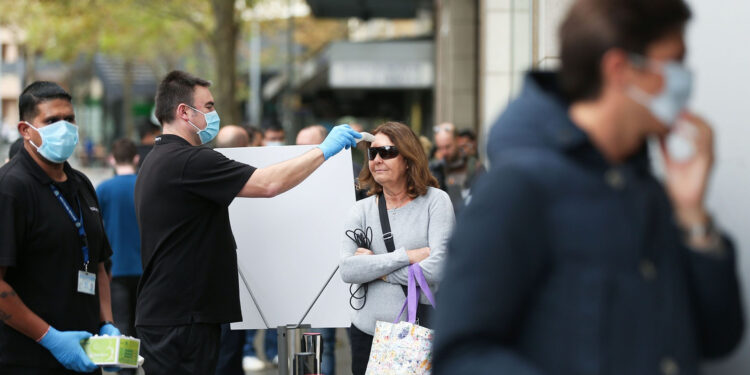 A customer has her temperature checked while waiting in line at an Apple Inc. store reopening, after being closed due to lockdown measures imposed because of the coronavirus, in the Bondi Junction suburb of Sydney, Australia, on Thursday, May 7, 2020. Apple's app store saw its strongest month of growth in two and a half years in April, according to Morgan Stanley, which wrote that "all major regions & categories saw accelerating spend" as a result of the pandemic. Photographer: Brendon Thorne/Bloomberg