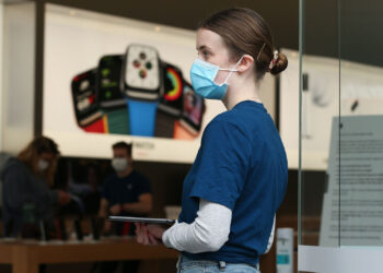 An employee wears a protective mask at an Apple Inc. store reopening, after being closed due to lockdown measures imposed because of the coronavirus, in the Bondi Junction suburb of Sydney, Australia, on Thursday, May 7, 2020. Apple's app store saw its strongest month of growth in two and a half years in April, according to Morgan Stanley, which wrote that "all major regions & categories saw accelerating spend" as a result of the pandemic. Photographer: Brendon Thorne/Bloomberg