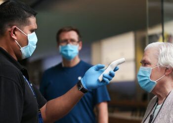 A customer wearing a protective mask has her temperature checked at an Apple Inc. store reopening, after being closed due to lockdown measures imposed because of the coronavirus, in the Bondi Junction suburb of Sydney, Australia, on Thursday, May 7, 2020. Apple's app store saw its strongest month of growth in two and a half years in April, according to Morgan Stanley, which wrote that "all major regions & categories saw accelerating spend" as a result of the pandemic. Photographer: Brendon Thorne/Bloomberg