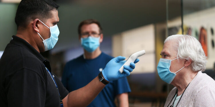 A customer wearing a protective mask has her temperature checked at an Apple Inc. store reopening, after being closed due to lockdown measures imposed because of the coronavirus, in the Bondi Junction suburb of Sydney, Australia, on Thursday, May 7, 2020. Apple's app store saw its strongest month of growth in two and a half years in April, according to Morgan Stanley, which wrote that "all major regions & categories saw accelerating spend" as a result of the pandemic. Photographer: Brendon Thorne/Bloomberg