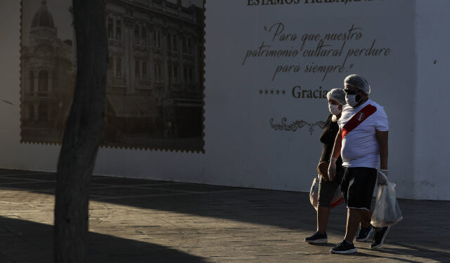 AME6162. LIMA (PERÚ), 27/04/2020.- Una pareja camina por una vacía Plaza San Martín este lunes, en el centro histórico de Lima (Perú). La recuperación de casos de COVID-19 en Perú se han ralentizado y actualmente hay más de 20.000 personas con la enfermedad activa en el país, donde el número de fallecidos llegó este lunes a 782 personas, según datos oficiales. EFE/ Paolo Aguilar