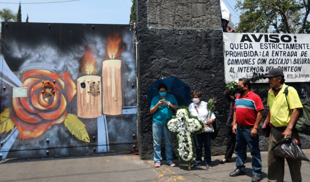 MEX535. CIUDAD DE MÉXICO (MÉXICO), 01/05/2020.- Personas con tapabocas esperan los restos de sus familiares el jueves 30 de abril en la entrada del panteón de San Nicolás Tolentino, en Ciudad de México (México). Los hornos crematorios de la capital mexicana están al límite de su capacidad cuando el país todavía no ha alcanzado el pico de contagios y muertos por la pandemia de COVID-19, mientras las funerarias sugieren el uso de fosas para albergar a los fallecidos. EFE/Sashenka Gutierrez