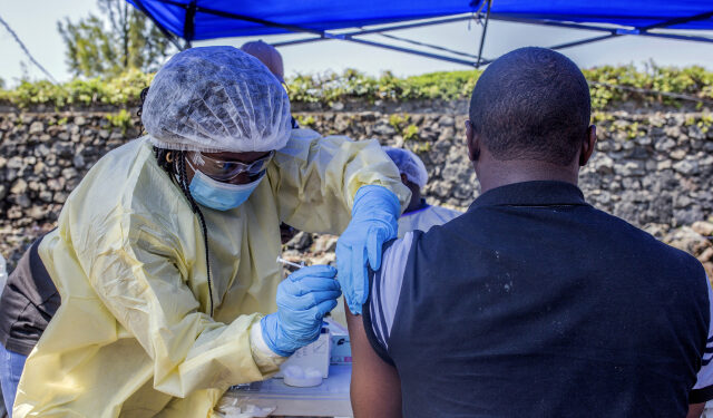 A man receives a vaccine against Ebola from a nurse outside the Afia Himbi Health Center on July 15, 2019 in Goma. - Authorities in Democratic Republic of Congo have appealed for calm after a preacher fell ill with Ebola in the eastern city of Goma, the first recorded case of the disease in the region's urban hub in a nearly year-old epidemic. (Photo by Pamela TULIZO / AFP)