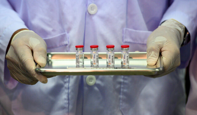 This picture taken on May 23, 2020 shows a laboratory technician holding a tray with doses of a COVID-19 novel coronavirus vaccine candidate ready for trial on monkeys at the National Primate Research Center of Thailand at Chulalongkorn University in Saraburi. - After conclusive results on mice, Thai scientists from the centre have begun testing a COVID-19 novel coronavirus vaccine candidate on monkeys, the phase before human trials. (Photo by Mladen ANTONOV / AFP)