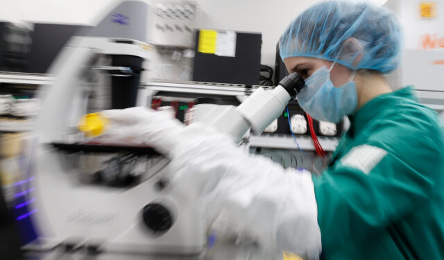 A scientist examines COVID-19 infected cells under a microscope during research for a vaccine against the coronavirus disease (COVID-19) at a laboratory of BIOCAD biotechnology company in Saint Petersburg, Russia May 20, 2020. REUTERS/Anton Vaganov