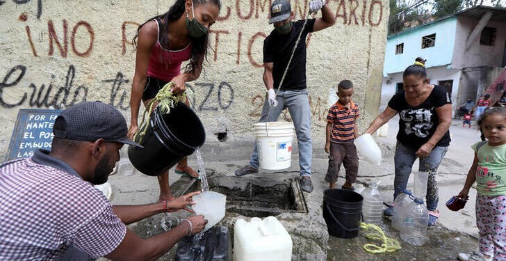 Personas extraen agua de una fuente desconocida en el vecindario de bajos ingresos de Petare, en medio del brote de la enfermedad por coronavirus (COVID-19) en Caracas, Venezuela. 3 de junio de 2020. REUTERS/Manaure Quintero