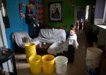 Varios cubos, algunos de ellos llenos con agua proporcionada por un camión cisterna gubernamental, en la sala de estar de una casa en el vecindario de Petare, en Caracas, Venezuela, el 15 de junio de 2020. El colapso económico de Venezuela ha dejado a la mayoría de los hogares sin un suministro de agua corriente confiable. ARIANA CUBILLOS AP