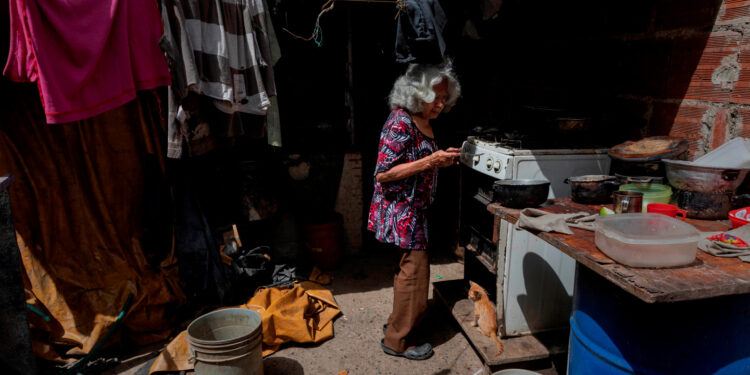 ACOMPAÑA CRÓNICA VENEZUELA CRISIS***AME2816. CARACAS (VENEZUELA), 16/07/2020.- Fotografía fechada el 11 de julio de 2020 de una anciana cocina en su vivienda improvisada en un terreno ocupado en Caracas (Venezuela). De acuerdo con la Encuesta de Condiciones de Vida (Encovi), en Venezuela casi uno de cada diez niños menores de cinco años -unos 166.000- padece algún tipo de desnutrición si se atiende a la relación entre su peso y edad. Y si la relación es entre talla y edad, el dato salta a tres de cada diez, es decir, 639.000 infantes. El número no extraña a los venezolanos, que atraviesan hace más de un lustro por la peor crisis que ha visto el país en su historia moderna. EFE/ Rayner Peña R.