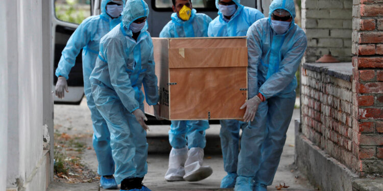 Healthcare workers carry the body of a Central Reserve Police Force (CRPF) member who died of the coronavirus disease (COVID-19), for his cremation at a crematorium in Srinagar July 18, 2020. REUTERS/Danish Ismail