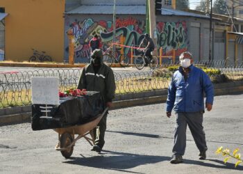 Personas son vistas mientras llevan un ataúd con un fallecido por coronavirus como protesta por no poder enterrarlo o incinerarlo, este sábado en Cochabamba (Bolivia). EFE/Jorge Ábrego