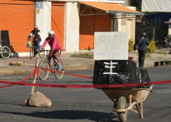 Un ataúd con un fallecido por coronavirus fue colocado en plena calle como protesta por no poder enterrarlo o incinerarlo, este sábado en Cochabamba (Bolivia). EFE/Jorge Ábrego