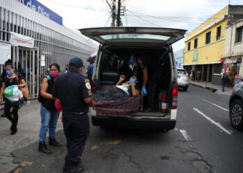 Municipal firefighters transfer a patient with symptoms related to the novel coronavirus at the COVID-19 unit of San Juan de Dios hospital in Guatemala City on July 13, 2020. - Doctors, deputies and the Human Rights Procurators Office (PDH) have raised the alarm about the imminent collapse of Guatemala's health system due to the increase of COVID-19 cases. (Photo by Johan ORDONEZ / AFP)