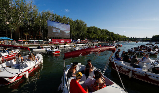 People arrive to watch the film "Le Grand Bain" from boats at the Cinema on the water (Cinema sur l?eau) as a floating cinema with 38 socially-distant electric boats kicks off the Paris Plages summer event along the Bassin de la Villette, in Paris following the outbreak of the coronavirus disease (COVID-19) in France July 18, 2020. REUTERS/Gonzalo Fuentes